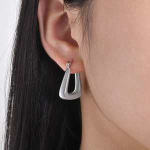 Minimalist stainless steel U-shaped hoop earrings worn by a model in a modern style