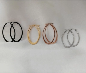 Close-up of four-piece minimalist oval hoop earrings set in black gold rose gold and silver