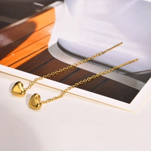 Gold stainless steel heart threader earrings with a polished finish on white desk