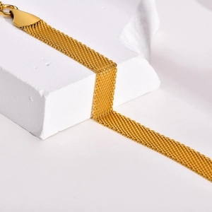 Close-up of golden mesh chain bracelet showing detailed texture and polished clasp