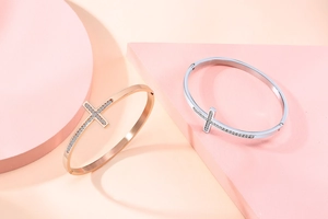 Détail de joncs croix en or rose et argent sertis de zircons brillants de luxe