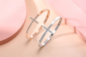 Détail d'un bracelet jonc en acier inoxydable avec un motif de croix serti de cristaux