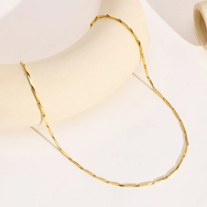 Macro view of minimalist 18k gold plated stainless steel bamboo link chain necklace