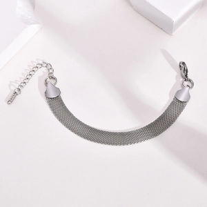 Detailed macro view of silver mesh bracelet with K18 tag and adjustable lobster clasp