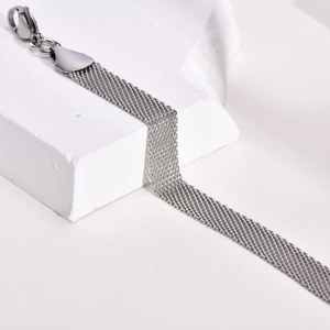 Macro detail of silver mesh strap bracelet featuring parallel chains and lobster clasp