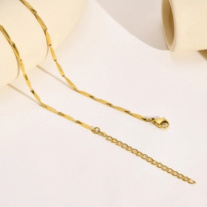 Detail view of the 18k gold tube chain necklace featuring faceted links and lobster clasp