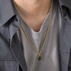Golden box chain necklace with black irregular oval pendant on male model