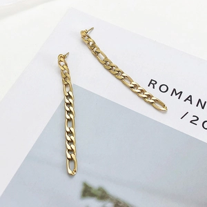 Macro detail of gold Figaro chain earrings showing textured links and metallic luster