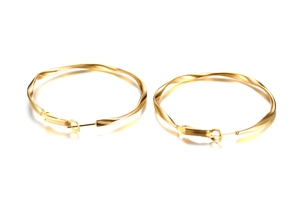 Detailed view of polished golden Mobius twist hoop earrings in stainless steel