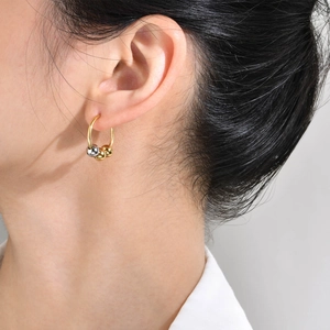 Minimalistische goldene Creolen mit drei Gleitperlen, am Model präsentiert