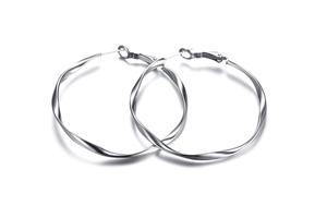 Macro shot of twisted silver stainless steel hoop earrings with reflective spiral design