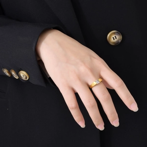Polished 18k gold titanium steel ring with a square green zircon on a model's finger