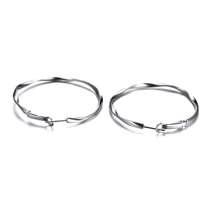 Macro detail of silver Mobius twist large hoop earrings with polished metal texture