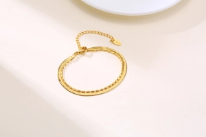 Macro shot of double-layer gold snake and bead chain bracelet with K18 engraving detail