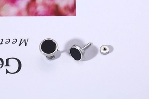 Macro view of stainless steel stud earrings with black inlay and secure screw back design