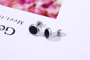 Macro detail of silver stainless steel earrings with black inlay and screw-back closure