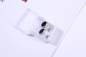 Close-up of stainless steel turquoise stud earrings set in a white plastic jewelry box