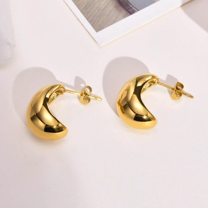 Detailed view of polished gold geometric crescent stud earrings in stainless steel