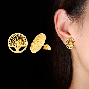 Détail de boucles d'oreilles Arbre de Vie dorées montrant le design et l'effet porté