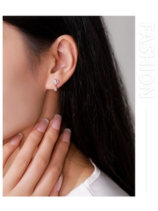 Close-up of 925 sterling silver drop earrings with pavé cubic zirconia on a model