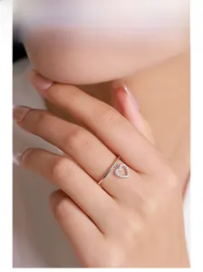 Close-up of S925 sterling silver ring featuring a dangling heart pendant with pavé zircons