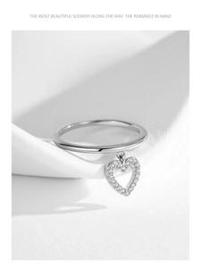 Macro shot of 925 sterling silver ring featuring a dangling hollow heart with pavé zircons