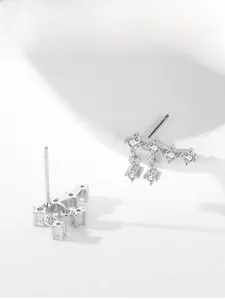Detailed view of silver star stud earrings with dangling tassels and micro-set cubic zirconia