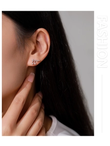 Close-up of 925 sterling silver star tassel earrings with zircon on a model ear