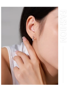 Gros plan sur les boucles d'oreilles pendantes en argent 925 avec zircon poire