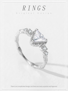 Macro detail of 925 silver ring featuring triangular clear gemstone and wavy band design