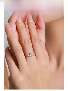 Detail shot of heart-cut diamond ring on model hand with elegant silver band