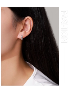 Dettaglio degli orecchini a C in argento sterling S925 con tre zirconi verticali scintillanti