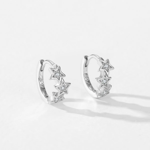 Boucles d'oreilles créoles en argent 925 avec étoiles et zircons sur fond blanc