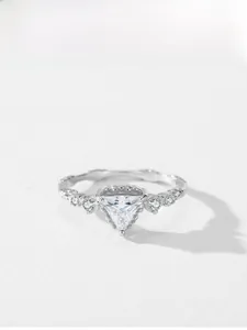 Macro view of vintage silver ring featuring triangle-cut stone and milgrain edging