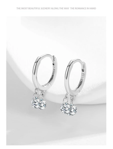 Détail des boucles d'oreilles créoles en argent 925 avec pampilles en zircons scintillants