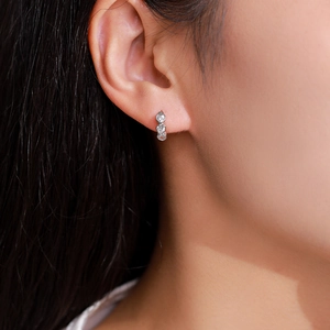 Orecchini a cerchio C in argento 925 con tre cuori verticali in zircone sulla modella