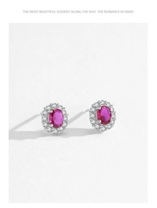 Detailed close-up of 925 silver stud earrings with oval red zircon and halo setting
