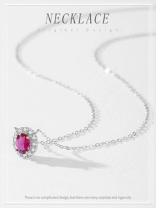 Macro shot of oval ruby pendant with cubic zirconia halo on silver chain necklace