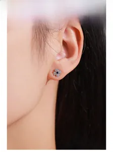 Detail of 925 silver four-leaf clover earrings with blue gemstone and pavé zircons