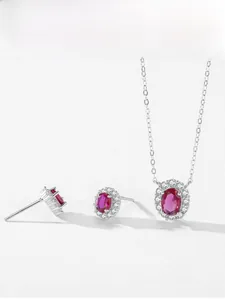 Macro detail of 925 sterling silver halo jewelry set with oval ruby gemstones