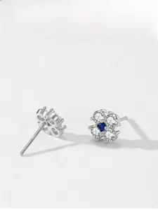 Detail of 925 silver clover earrings with blue sapphire center and pavé zircon stones