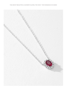 Close-up of 925 sterling silver necklace with oval ruby pendant and diamond halo