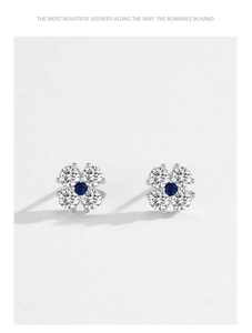 Macro detail of 925 sterling silver four-leaf clover studs with blue and clear zircons