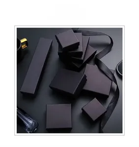 Exquisite black matte jewelry gift box set with satin ribbons on minimalist dark desk
