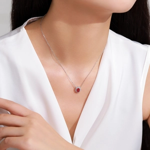 925 sterling silver ruby pendant necklace with oval halo design worn by a model