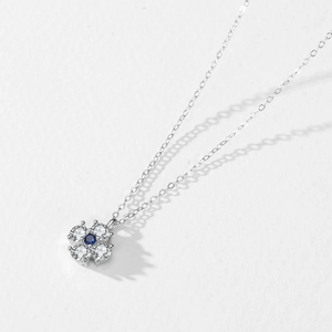 Collier en argent 925 avec tournesol, zircons et pierre bleue sur une surface blanche