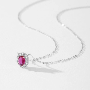 925 silver necklace with oval ruby gemstone and halo diamond setting on white background