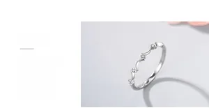 Dettaglio macro dell'anello ondulato in argento S925 con tre micro diamanti incastonati