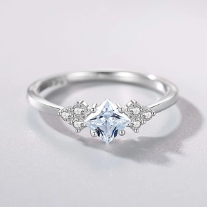 Elegant S925 silver ring with princess-cut blue gemstone and side diamonds on purple backdrop