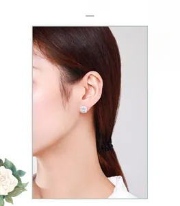 Close-up of s925 silver square cz stud earring worn on ear with halo diamonds